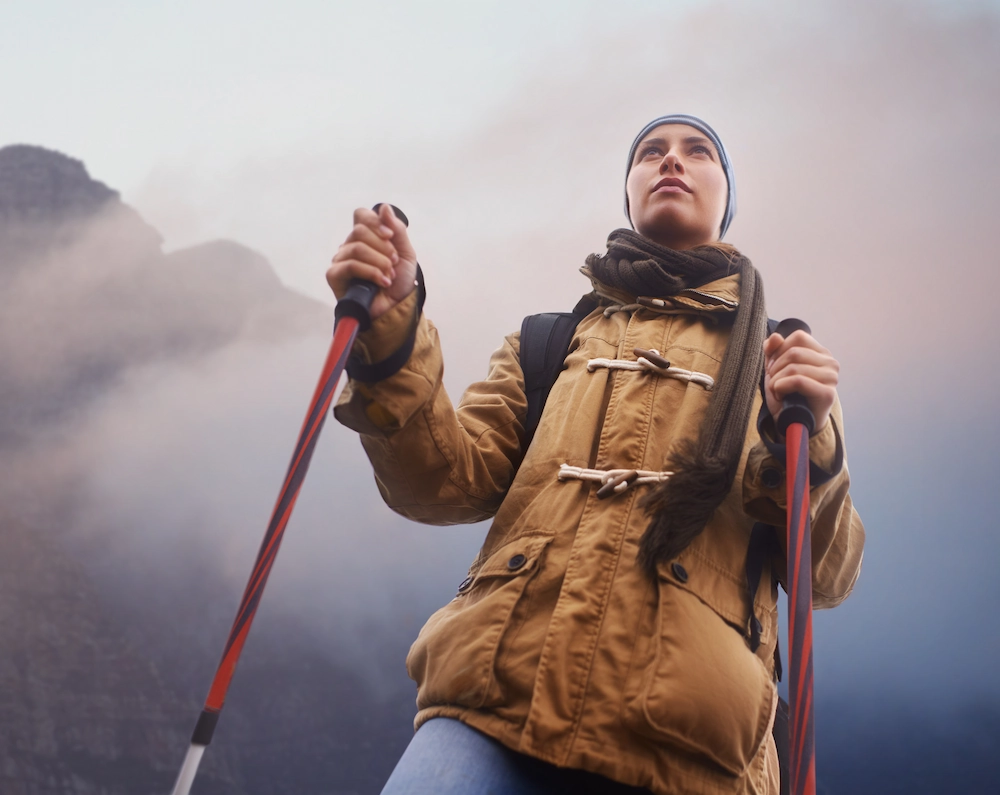 woman hiking with trekking poles. During a zombie apocalypse, trekking poles make great weapons
