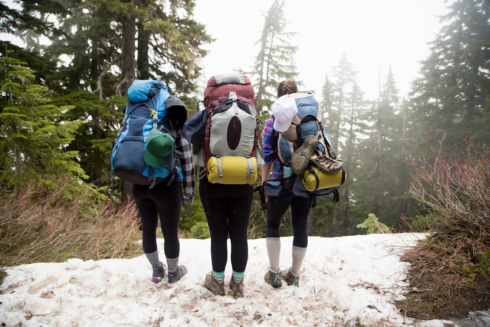 group of women hiking and backpacking in winter