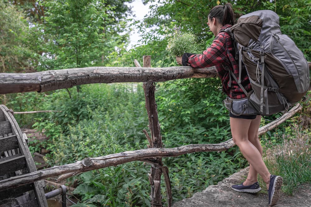 girl hiker with massive overstuffed backpack and incorrect hiking shoes