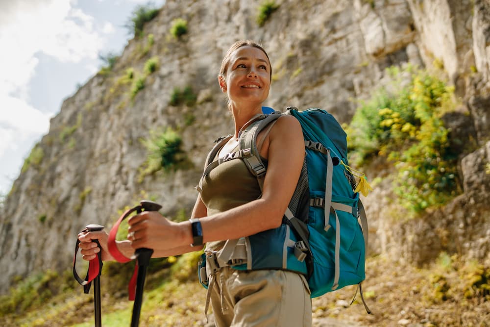 a beginner hiker on a mountain trail avoiding beginner hiking mistakes